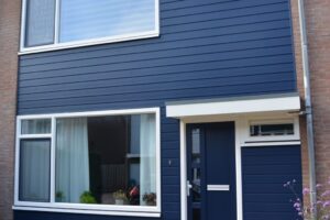 Een blauwe gevelbekleding en nieuwe kunststof kozijnen op een tussenwoning geplaatst door Maatkamp